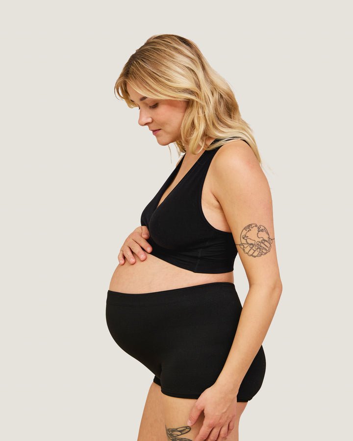Gravid model med sorte Carriwell trusser med høj talje set fra siden